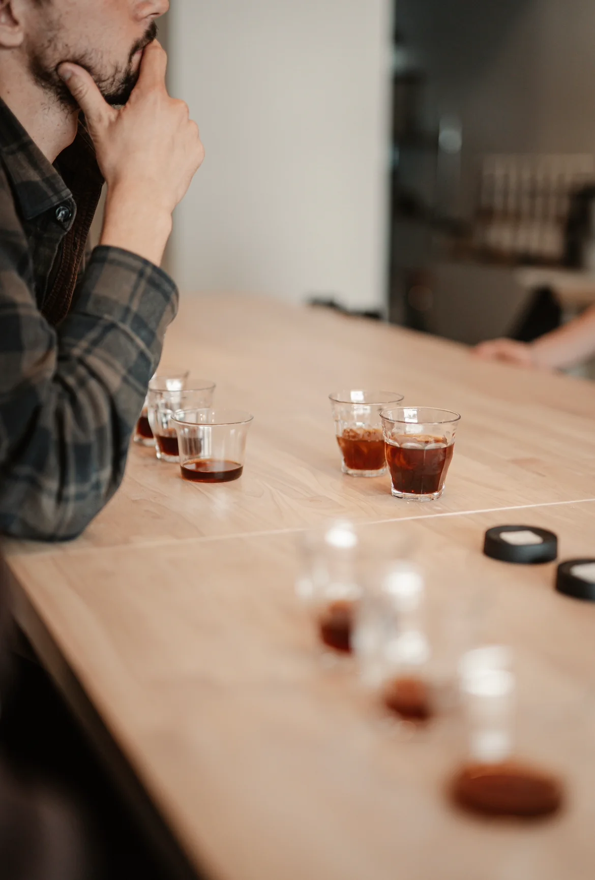 Shots of coffee lined up on a bar.