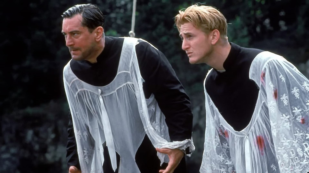 Two man in priest outfits are soaking wet.